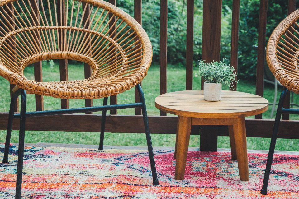 Wooden outdoor chairs and a small table on a porch